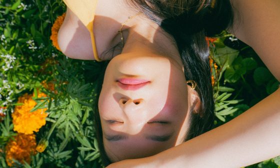 A person lies amongst a bed of marigolds.