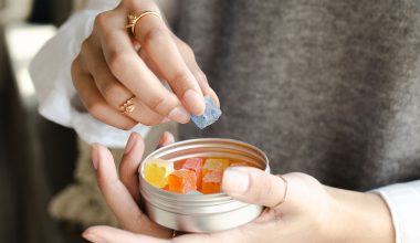 a person reaching into a container to take out a gummy supplement