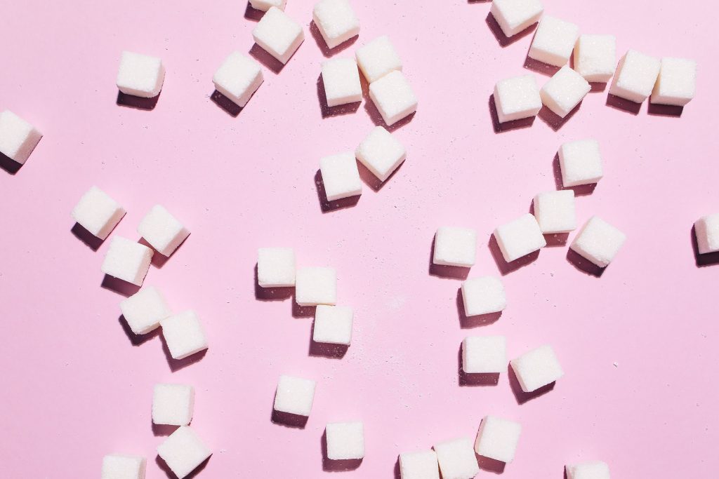 sugar cubes scattered across pink backdrop